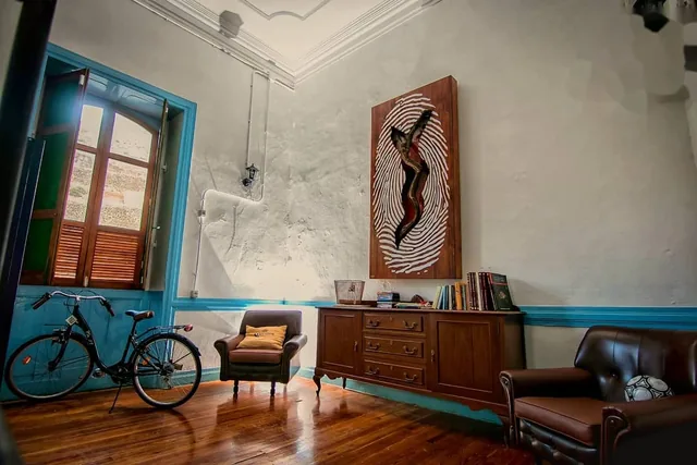 Salón de la casa, con butacas de cuero y las paredes de piedra encaladas